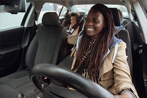 Woman driving Motability car with child in back